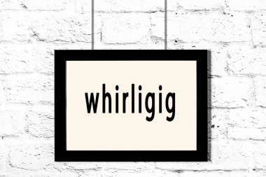 Beyaz tuğla duvarda asılı siyah çerçeve ve yazı girdabı