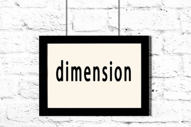 Beyaz tuğla duvarda asılı siyah çerçeve ve yazı boyutu