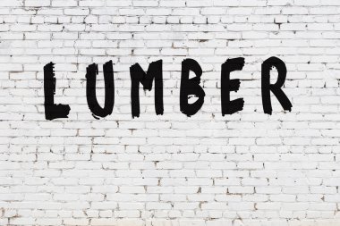 Üzerinde siyah boya yazılı kereste olan beyaz duvar.