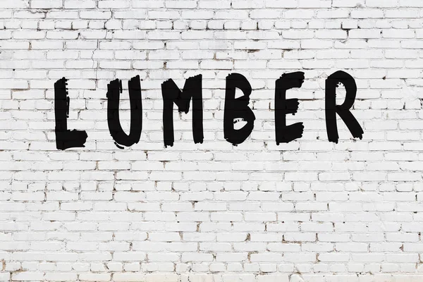 Üzerinde siyah boya yazılı kereste olan beyaz duvar.