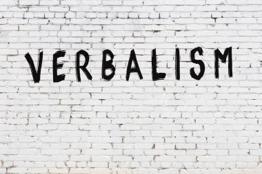 Üzerinde siyah boya yazılı sözlü beyaz duvar.