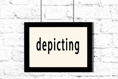 Beyaz tuğla duvarda asılı siyah çerçeve.