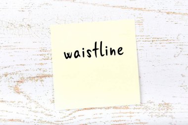 Tahta duvarda el yazısıyla yazılmış sarı yapışkan bir not var.