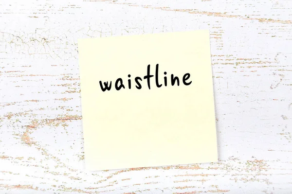 Tahta duvarda el yazısıyla yazılmış sarı yapışkan bir not var.