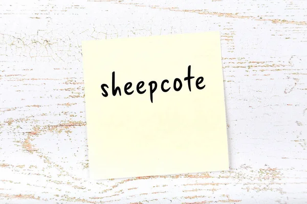 Tahta duvardaki sarı yapışkan notta el yazısıyla yazılmış koyunlar var.