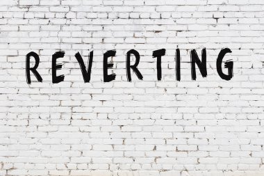 Kelimeler beyaz tuğla duvara yazılıyor.