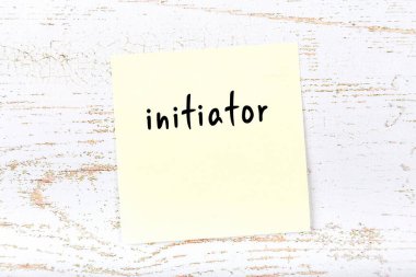 Tahta duvarda el yazısıyla başlatılan sarı yapışkan bir not.