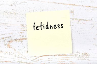 Tahta duvarda el yazısıyla yazılmış saplantılı sarı bir not.