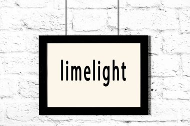 Beyaz tuğla duvarda asılı siyah çerçeve.