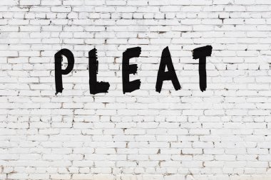 Beyaz tuğla duvara yazı yazılmış.