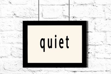 Beyaz tuğla duvarda asılı duran siyah çerçeve.