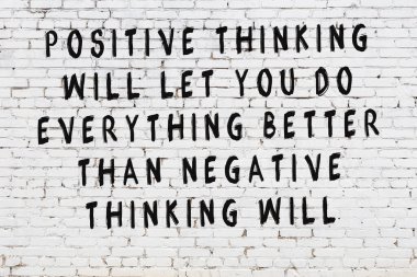 Beyaz tuğla duvara zekice alıntılar yazılı siyah bir yazı.