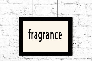 Beyaz tuğla duvarda asılı siyah çerçeve ve güzel kokulu.