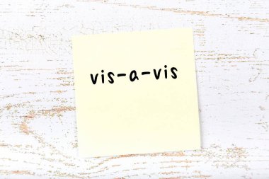 Tahta duvarda, el yazısıyla yazılmış sarı yapışkan bir not var.