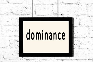 Beyaz tuğla duvarda asılı siyah çerçeve ve yazı üstünlüğü