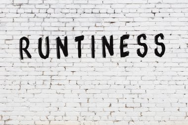 Üzerinde siyah boya yazıları olan beyaz bir duvar.