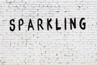 Üzerinde siyah boya yazılı beyaz duvar parlıyor.