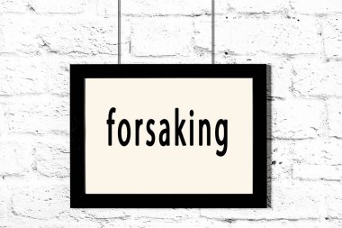 Beyaz tuğla duvarda asılı duran siyah çerçeve.