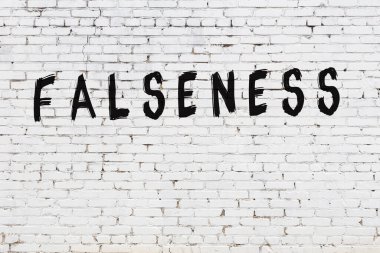 Üzerinde siyah boya yazıları olmayan beyaz bir duvar.