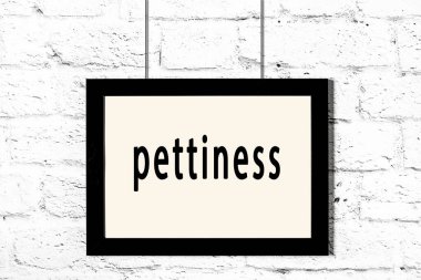 Beyaz tuğla duvarda asılı siyah çerçeve.