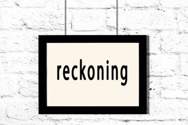 Beyaz tuğla duvarda asılı siyah çerçeve ve yazı tahmini