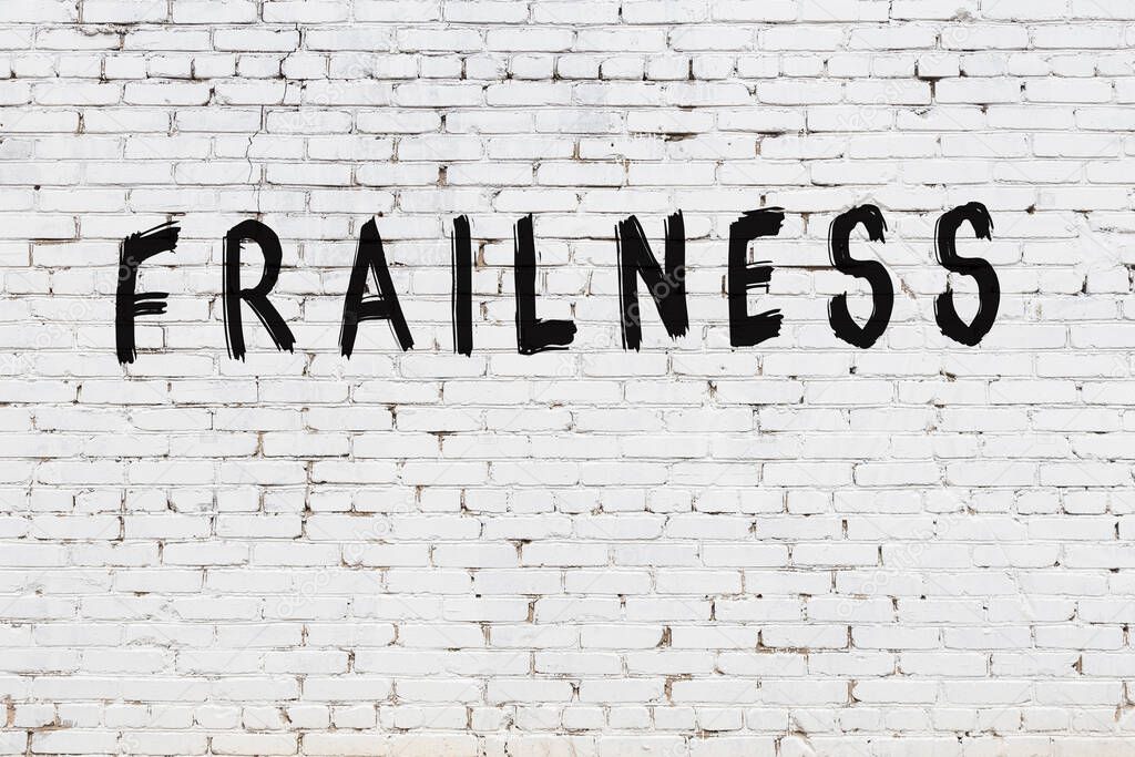 Word frailness painted on white brick wall