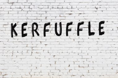 Üzerinde siyah boya yazıtları olan beyaz duvar.