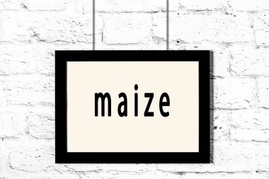 Beyaz tuğla duvarda asılı siyah çerçeve.