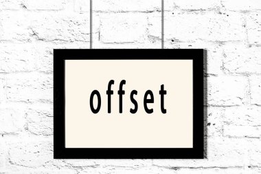 Beyaz tuğla duvarda asılı duran siyah çerçeve.