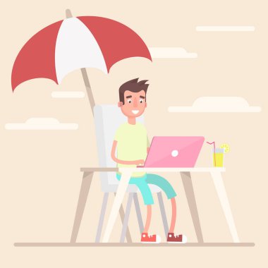 Bir çalışan yaz aylarında sahilde bir şemsiye altında çalışır.