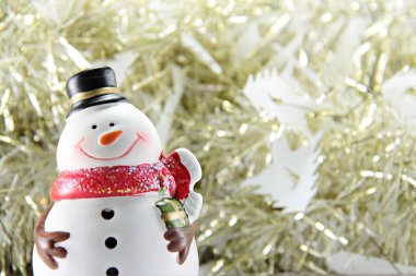 Altın flama veya tinsel arka plan üzerinde sevimli kardan adam