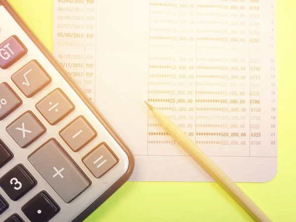 Calculadora, lápiz y libreta de ahorros sobre fondo amarillo — Foto de Stock