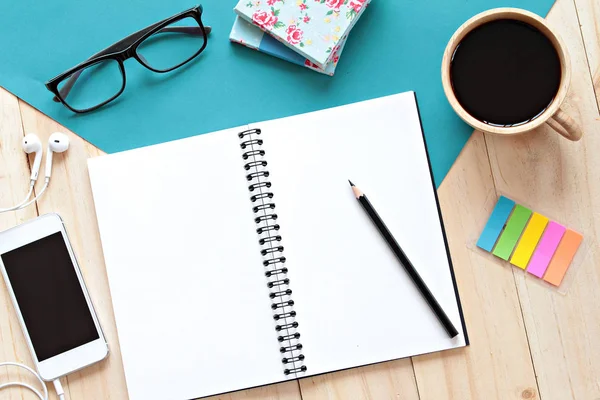 Top view image of open notebook with blank pages, mobile phone and coffee cup on wooden background, ready for adding or mock up — Stock Photo, Image