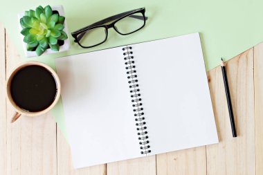 açık defter ile boş sayfaları ve kahve fincanı ahşap arka plan eklemek için hazır veya sahte kadar üzerinde görüntüsünü Üstten Görünüm