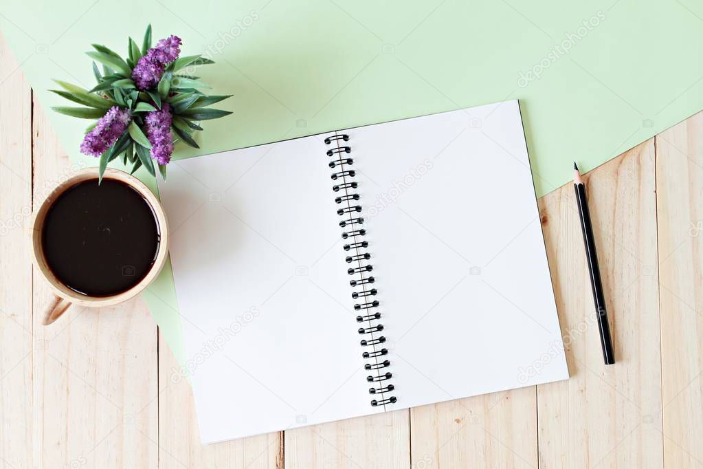 top view image of open notebook with blank pages and coffee cup on wooden background, ready for adding or mock up