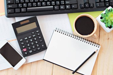 Office tablo Resepsiyon çalışma alanı boş defter, akıllı telefon, hesap makinesi, bilgisayar klavye ve kahve ile alay et