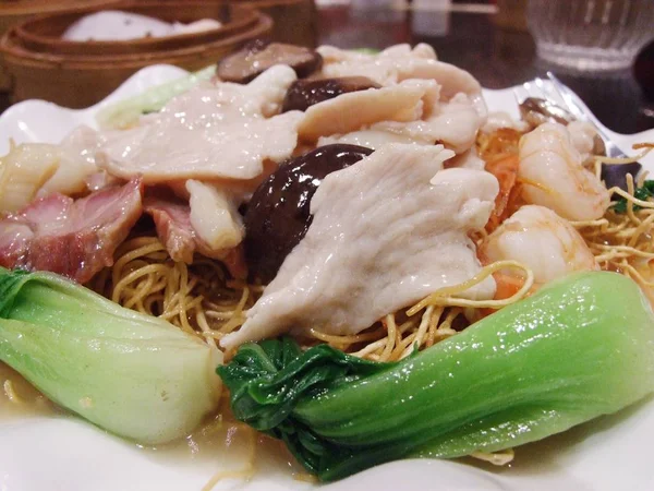 Fideos de huevo crujientes de comida china con cerdo, mariscos y col rizada china — Foto de Stock