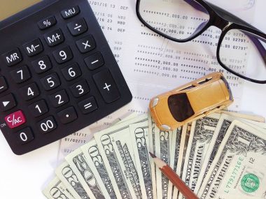 Minyatür araba modeli, kalem, para, hesap makinesi, gözlük ve tasarruf hesabı hesap cüzdanı veya beyaz arka plan üzerinde mali tablo