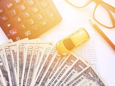 Minyatür araba modeli, kalem, hesap makinesi, gözlük, para ve tasarruf hesabı hesap cüzdanı veya beyaz arka plan üzerinde mali tablo