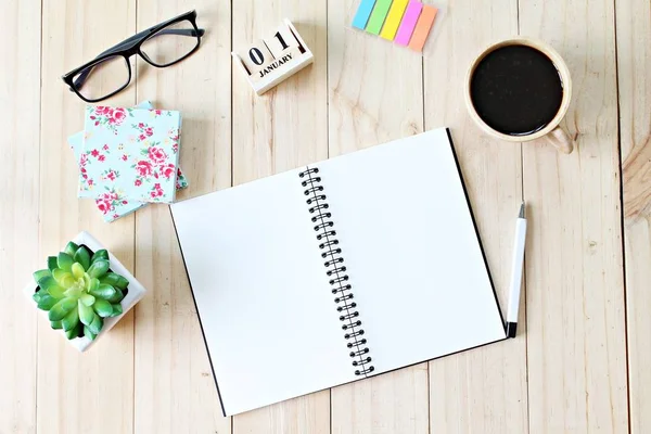 나무 배경에 펜, 커피 컵, 다채로운 노트 패드, 큐브 달력 안경 빈 노트북 책상의 상위 뷰 — 스톡 사진