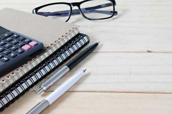 Notebooks, calculator and eyeglasses on office desk table — Stock Photo, Image