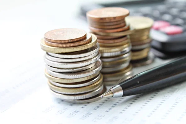 Стек монет, ручка і калькулятор для збереження рахунку або фінансової звітності — стокове фото