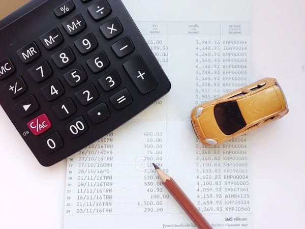 Modèle de voiture miniature, calculatrice et livret de compte d'épargne ou état financier sur table de bureau — Photo