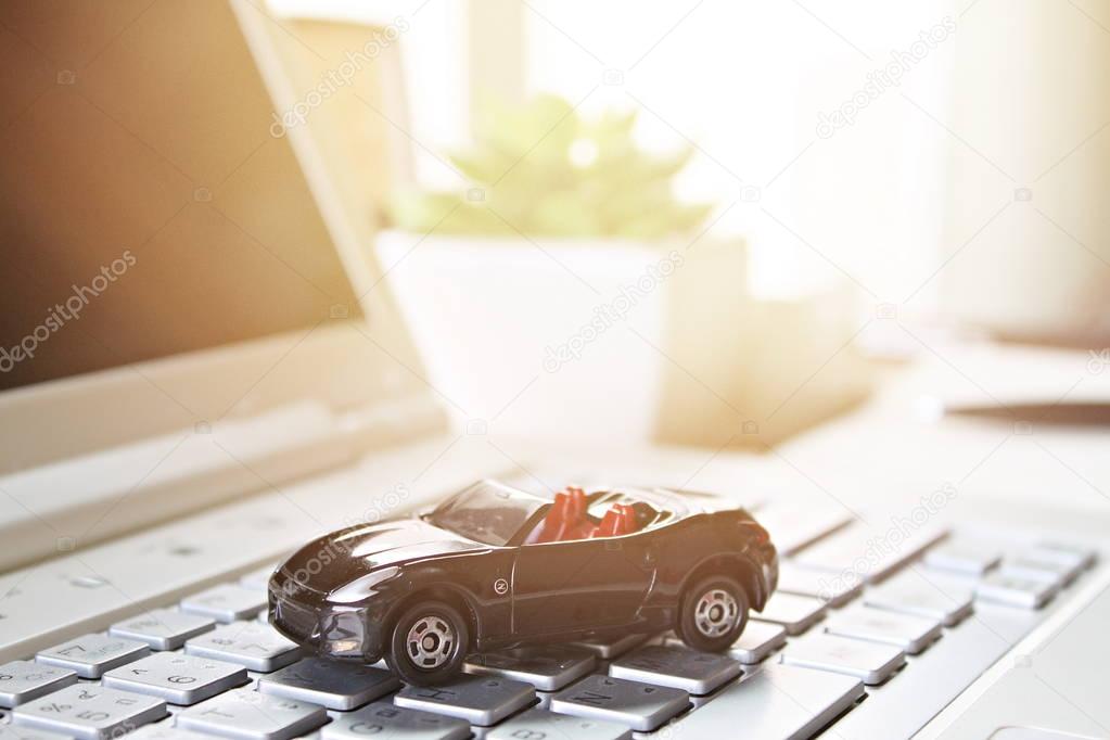Miniature car model on computer laptop