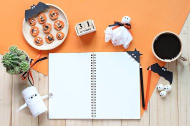 Yukarı alay açık defter, kağıt el sanatları, küp takvim, korkutucu yüz ve kahve fincanı ile ızgara havuç