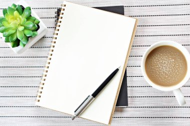 Üstten Görünüm veya düz yatıyordu görüntü açık defter ile boş sayfaları ve tablo arka plan eklemek için hazır veya sahte kadar üzerinde kahve fincanı