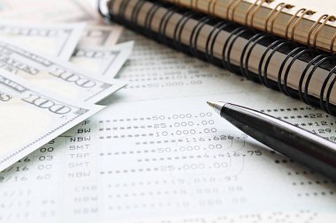 İş, finans, para, yatırım veya muhasebe kavram kaydetme: Amerikan Doları nakit para, defter, kalem ve tasarruf hesabı hesap cüzdanı veya ofis resepsiyon masası üzerinde mali tablo