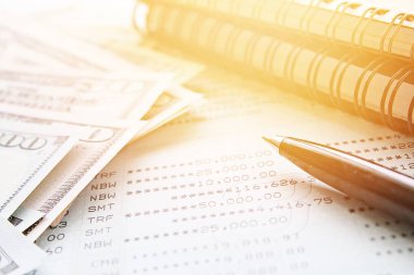 İş, finans, para, yatırım veya muhasebe kavram kaydetme: Amerikan Doları nakit para, defter, kalem ve tasarruf hesabı hesap cüzdanı veya ofis resepsiyon masası üzerinde mali tablo