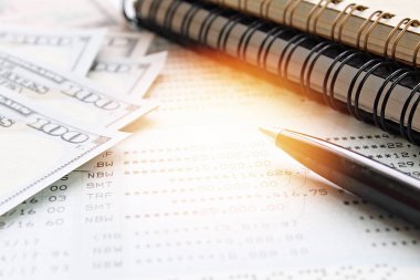 İş, finans, para, yatırım veya muhasebe kavram kaydetme: Amerikan Doları nakit para, defter, kalem ve tasarruf hesabı hesap cüzdanı veya ofis resepsiyon masası üzerinde mali tablo