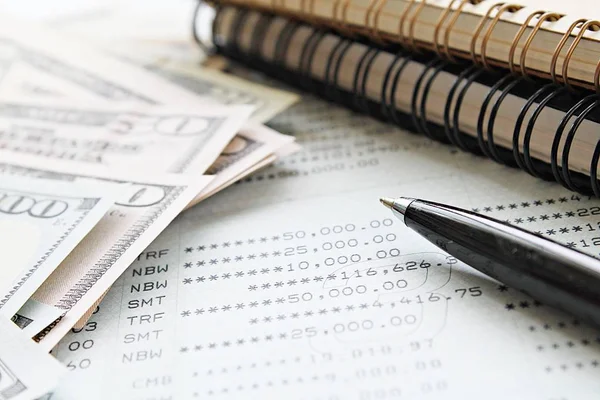İş, finans, para, yatırım veya muhasebe kavram kaydetme: Amerikan Doları nakit para, defter, kalem ve tasarruf hesabı hesap cüzdanı veya ofis resepsiyon masası üzerinde mali tablo